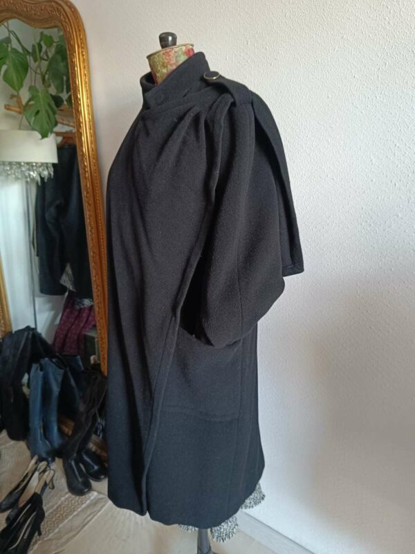 Magnifique manteau long noir de style vintage, doté d’une écharpe intégrée pour une allure élégante et structurée. Une pièce intemporelle, chic et facile à porter, idéale pour la saison automne/hiver.
