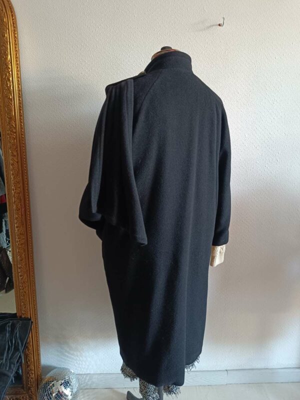 Magnifique manteau long noir de style vintage, doté d’une écharpe intégrée pour une allure élégante et structurée. Une pièce intemporelle, chic et facile à porter, idéale pour la saison automne/hiver.