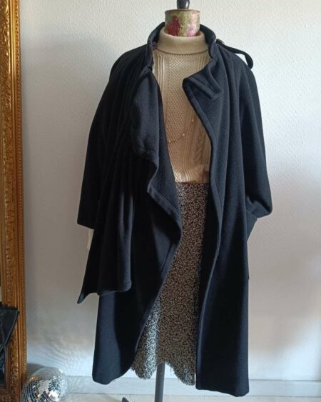 Magnifique manteau long noir de style vintage, doté d’une écharpe intégrée pour une allure élégante et structurée. Une pièce intemporelle, chic et facile à porter, idéale pour la saison automne/hiver.