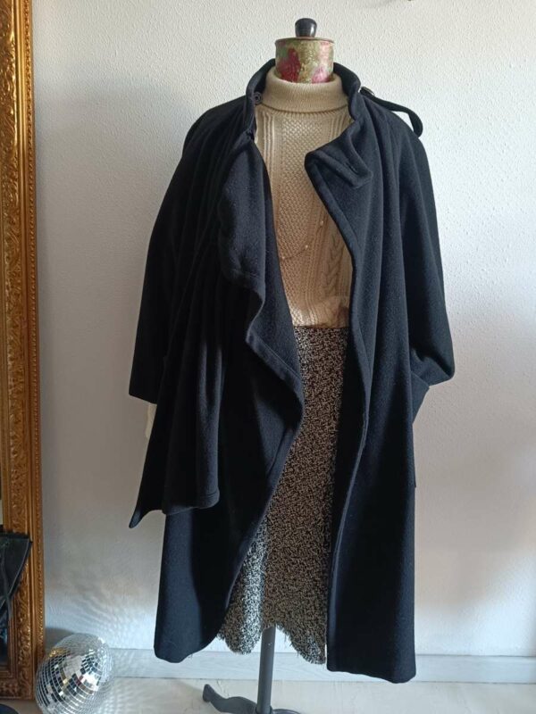 Magnifique manteau long noir de style vintage, doté d’une écharpe intégrée pour une allure élégante et structurée. Une pièce intemporelle, chic et facile à porter, idéale pour la saison automne/hiver.