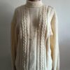Superbe maille torsadée vintage en laine, au style intemporel et chaleureux. Son jeu de torsades verticales et son col légèrement montant en font une pièce élégante et confortable, idéale pour la saison automne/hiver.