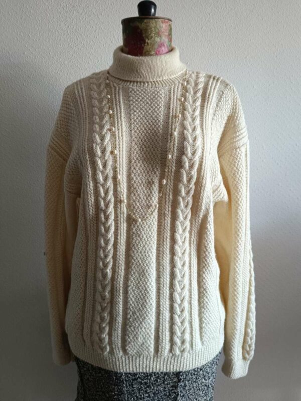 Superbe maille torsadée vintage en laine, au style intemporel et chaleureux. Son jeu de torsades verticales et son col légèrement montant en font une pièce élégante et confortable, idéale pour la saison automne/hiver.