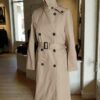 Description Trench beige Gérard Barrel, élégant et intemporel. Ce modèle chic se distingue par sa coupe structurée, sa ceinture qui souligne la silhouette et son gilet intérieur amovible, idéal pour s’adapter aux saisons plus fraîches. Confectionné principalement en coton, il offre un tombé net et une allure sophistiquée. Le trench présente quelques imperfections très discrètes, liées à la teinte claire du tissu, non perceptibles sur les photos et sans impact sur le porté. Une belle pièce de marque, pratique et élégante, en très bon état général.