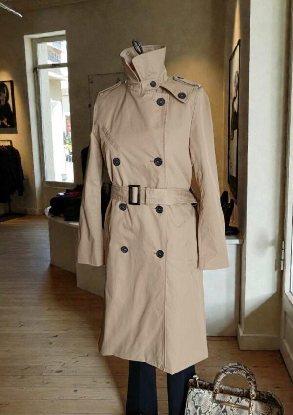 Description Trench beige Gérard Barrel, élégant et intemporel. Ce modèle chic se distingue par sa coupe structurée, sa ceinture qui souligne la silhouette et son gilet intérieur amovible, idéal pour s’adapter aux saisons plus fraîches. Confectionné principalement en coton, il offre un tombé net et une allure sophistiquée. Le trench présente quelques imperfections très discrètes, liées à la teinte claire du tissu, non perceptibles sur les photos et sans impact sur le porté. Une belle pièce de marque, pratique et élégante, en très bon état général.