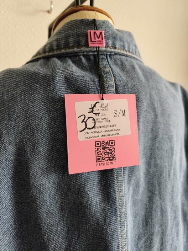 Originale veste sans manches en jean LM Lulu revisitée avec de larges franges roses et clous dorés qui lui donnent un style audacieux et très mode. Sa coupe ample permet de la porter facilement sur une robe, un top ou une chemise pour apporter une touche rock et bohème à une tenue. Une pièce forte qui attire immédiatement le regard.