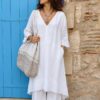 Kaftan Upcyclé « Rivage Blanc » – Taille Unique Confectionné à partir d'un drap ancien soigneusement sélectionné, ce kaftan de la collection Les Héritières incarne toute la douceur des étés méditerranéens. Sa coupe ample et aérienne accompagne naturellement les mouvements tout en offrant un confort exceptionnel. Son encolure en V met délicatement le port de tête en valeur tandis que ses poches discrètes renforcent son esprit pratique et décontracté. Le bas du vêtement est sublimé par une magnifique broderie anglaise ancienne qui apporte relief, finesse et élégance à cette pièce intemporelle. Porté avec un pantalon blanc en coton ou en lin, il compose une silhouette lumineuse inspirée de la French Riviera, entre simplicité raffinée et charme bohème. Chaque modèle est réalisé en exemplaire unique dans notre atelier à partir de textiles anciens revalorisés.