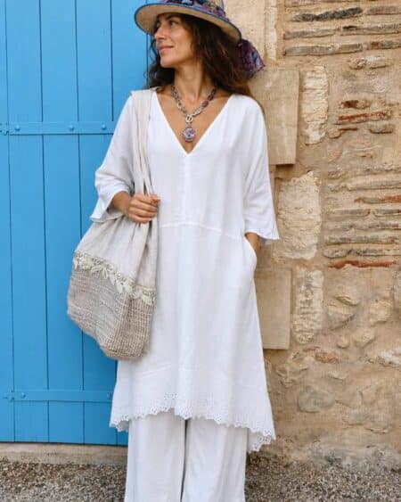 Kaftan Upcyclé « Rivage Blanc » – Taille Unique Confectionné à partir d'un drap ancien soigneusement sélectionné, ce kaftan de la collection Les Héritières incarne toute la douceur des étés méditerranéens. Sa coupe ample et aérienne accompagne naturellement les mouvements tout en offrant un confort exceptionnel. Son encolure en V met délicatement le port de tête en valeur tandis que ses poches discrètes renforcent son esprit pratique et décontracté. Le bas du vêtement est sublimé par une magnifique broderie anglaise ancienne qui apporte relief, finesse et élégance à cette pièce intemporelle. Porté avec un pantalon blanc en coton ou en lin, il compose une silhouette lumineuse inspirée de la French Riviera, entre simplicité raffinée et charme bohème. Chaque modèle est réalisé en exemplaire unique dans notre atelier à partir de textiles anciens revalorisés.