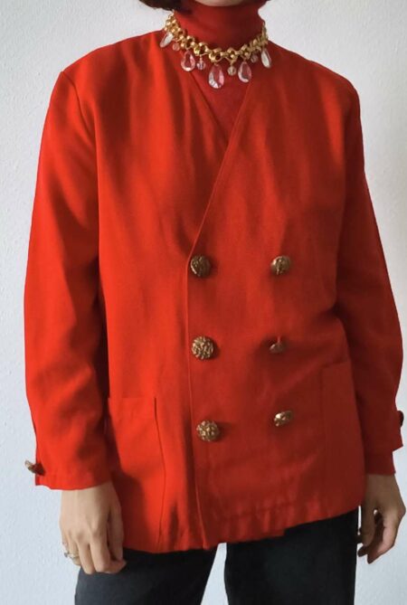Veste vintage rouge femme taille 44 à double boutonnage et boutons bijoux dorés, portée avec un pantalon noir.