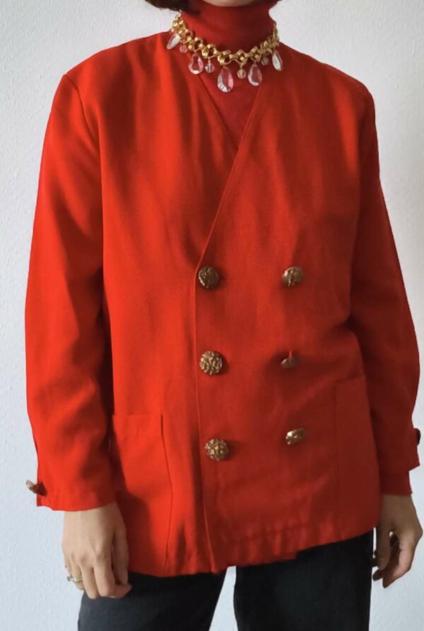 Veste vintage rouge femme taille 44 à double boutonnage et boutons bijoux dorés, portée avec un pantalon noir.
