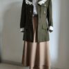 Jupe portefeuille en laine beige portée avec une veste militaire kaki vintage.